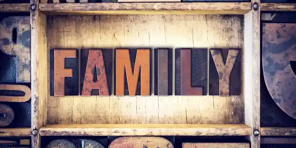 A wooden shelf with the word family written in wood type.