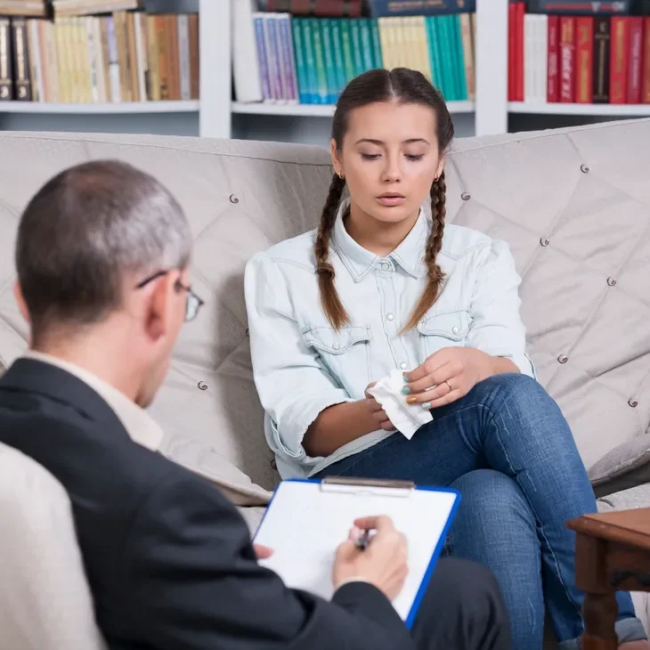 A woman sitting on the couch with a man.